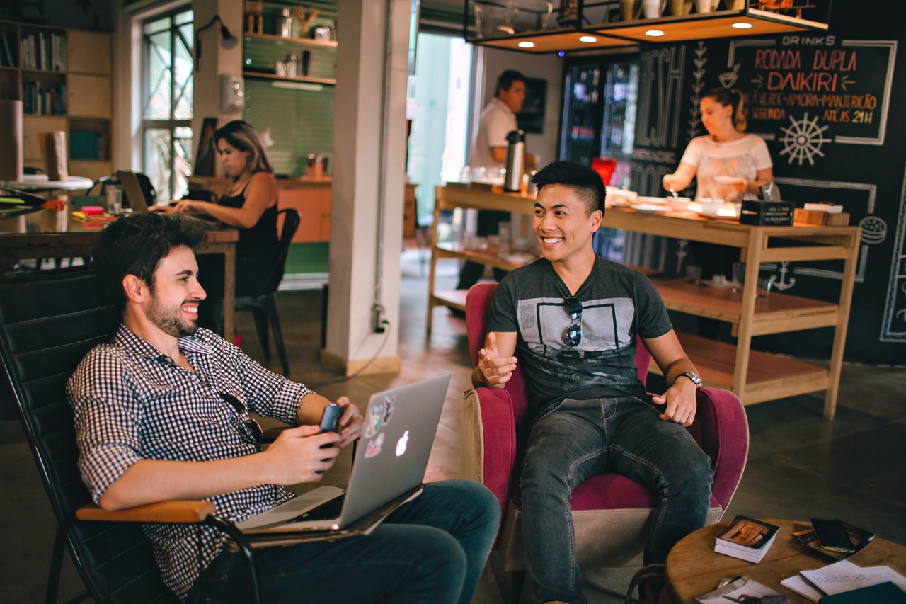 Men having conversation seating on chair.