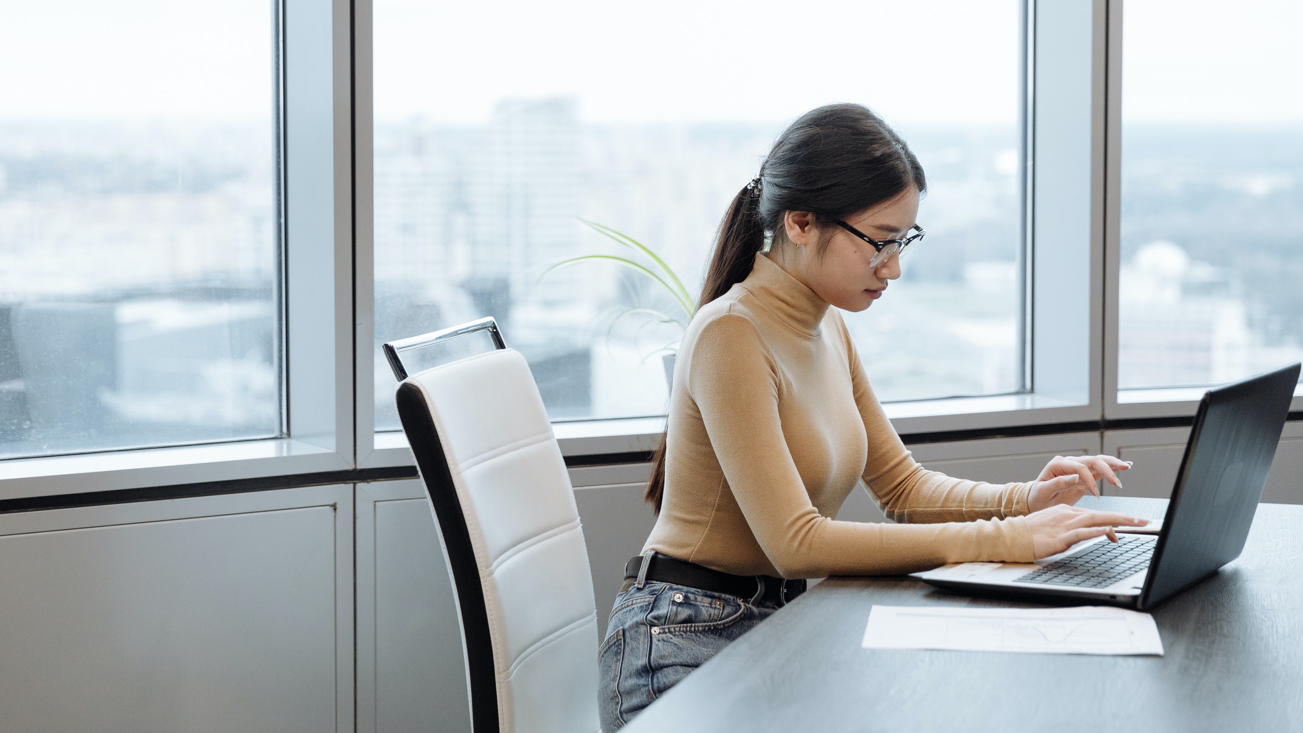 Woman in brown long sleeve shirt using laptop