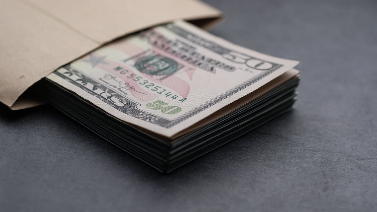 An envelope of dollar bills to make a monetary donation.